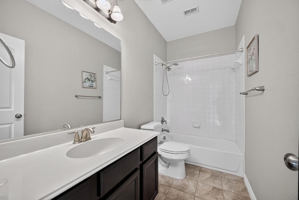 Dark wood-finish vanity with an integrated sink, brushed nickel faucet, and a large wall-mounted mirror