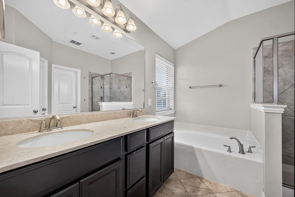 Dual vanity with integrated sinks, light-toned countertop, and dark wood-finish cabinetry