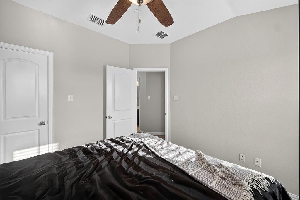 Vaulted ceiling with a wood-finish ceiling fan, neutral wall paint, and white paneled doors