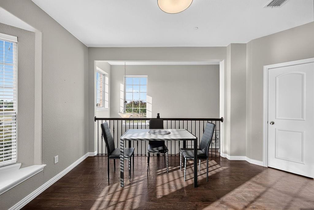 Open concept interior featuring wood-finish flooring, a contemporary ceiling light fixture, and white interior doors
