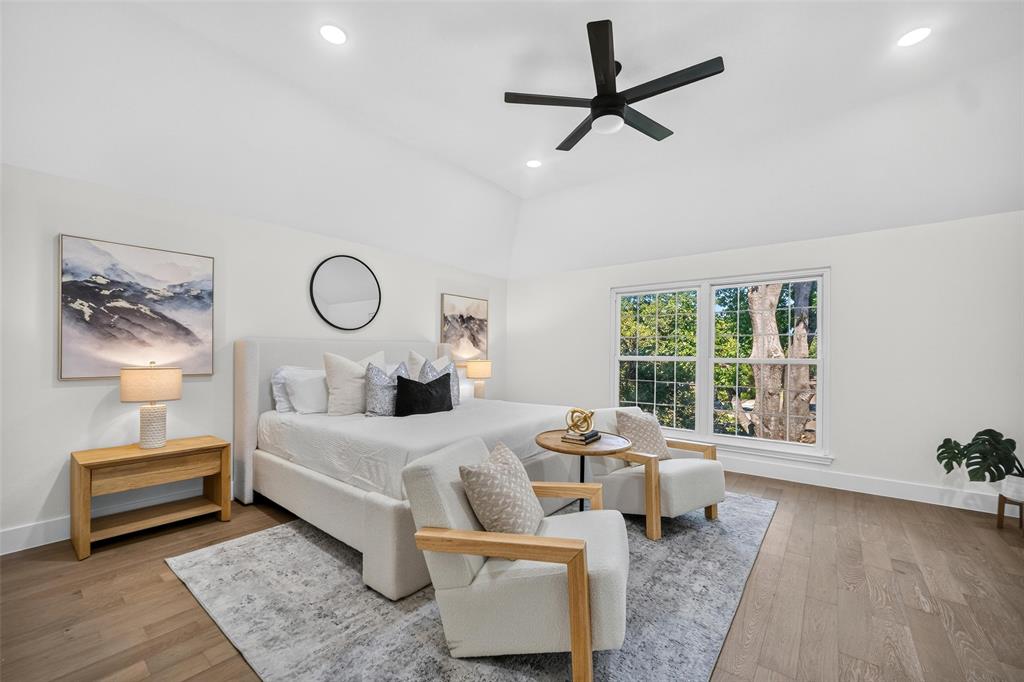 Vaulted ceiling, recessed lighting, wood-finish flooring, ceiling fan, and large window