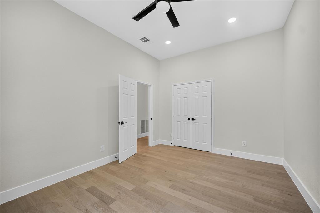 Vaulted ceiling with a ceiling fan, recessed lighting, wood-finish flooring, and white trim