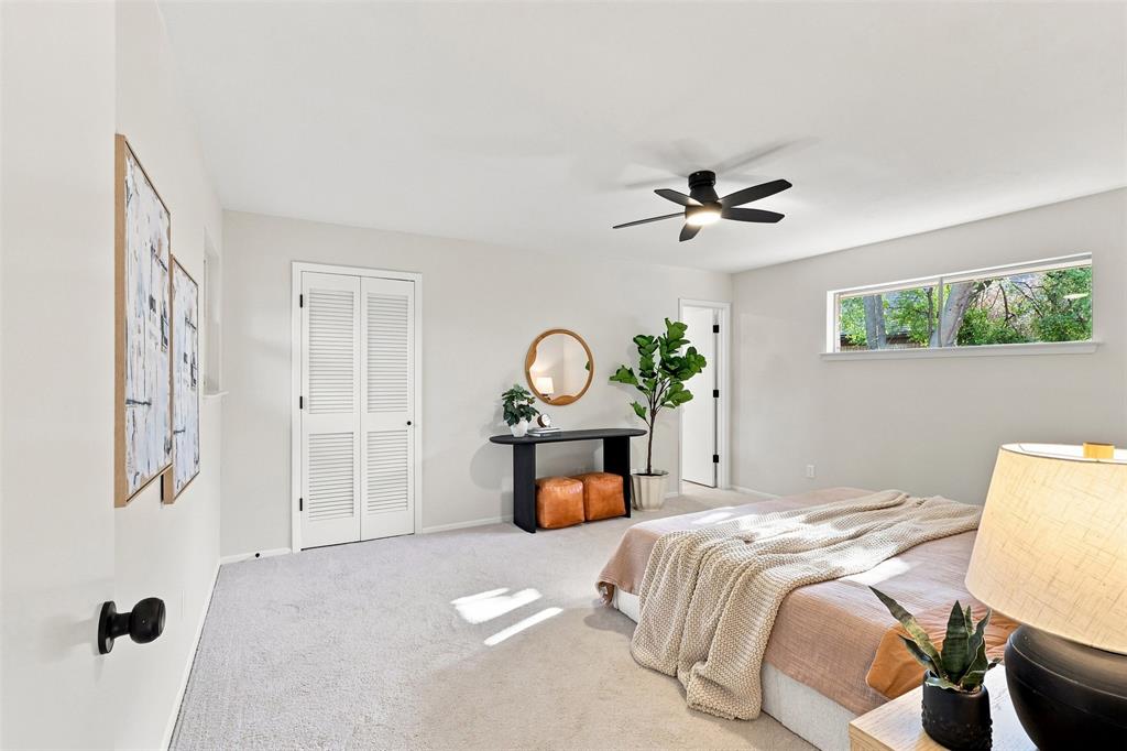 Soft gray carpeting, white walls, and a black ceiling fan with integrated lighting