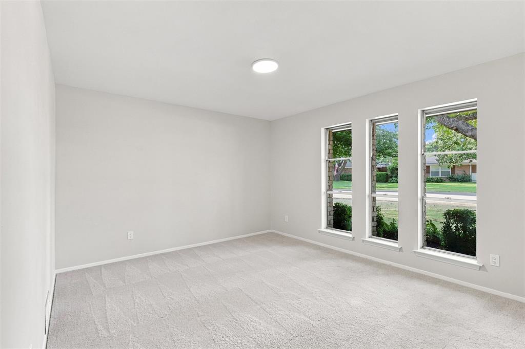 Neutral wall color, recessed ceiling light, and three vertical windows