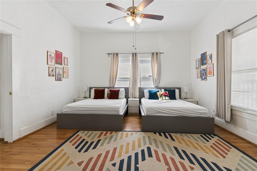 Hardwood-style flooring, white painted walls, and a ceiling fan with integrated lighting