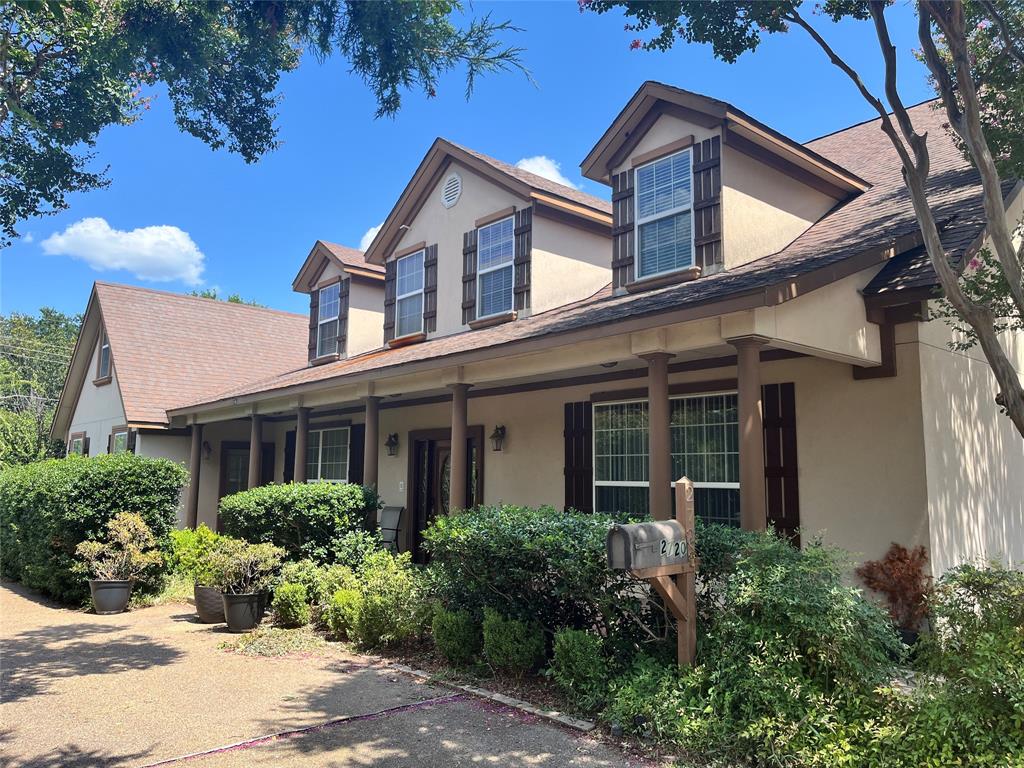 Pitched rooflines, multiple dormer windows, exterior shutters, covered front porch with pillars, and mature landscaping Pitched rooflines, multiple dormer windows, exterior shutters, covered front porch with pillars, and mature landscaping