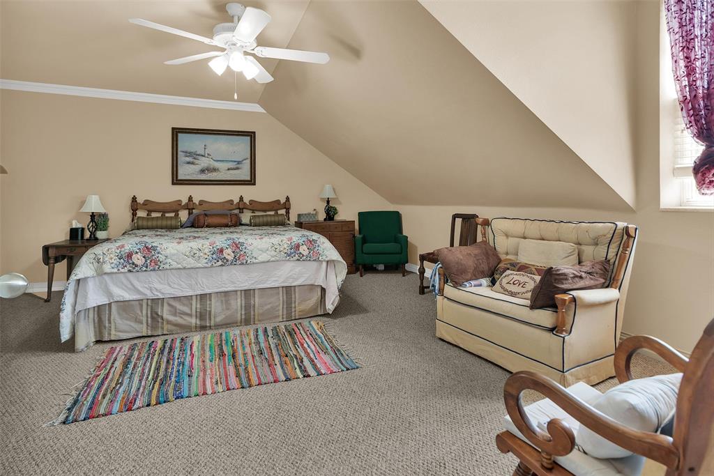 Carpeted room with sloped ceilings and a ceiling fan