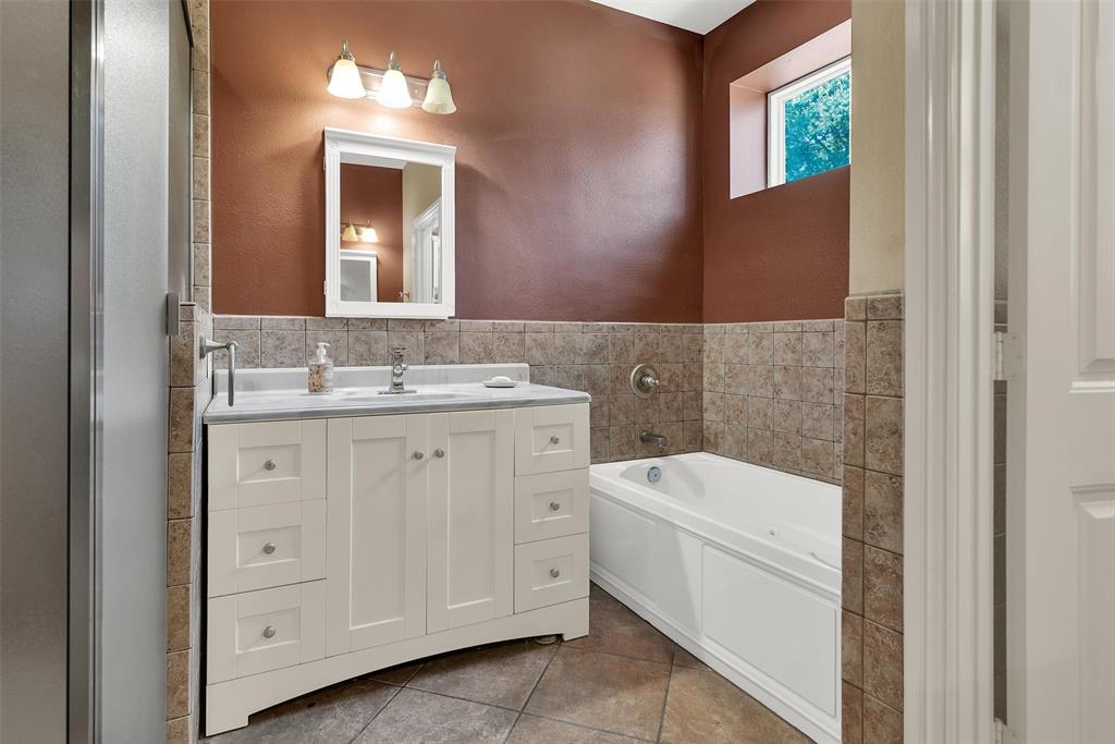 White vanity with stone countertop, integrated sink, and chrome fixtures