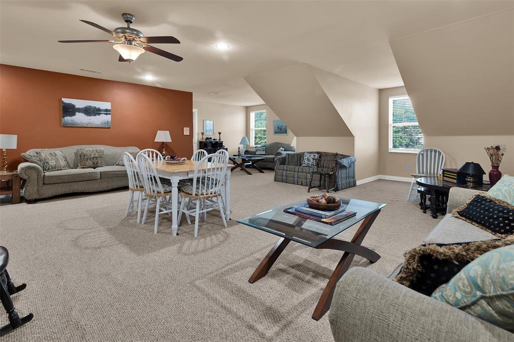 Expansive carpeted area with vaulted ceilings, recessed lighting, and multiple window openings