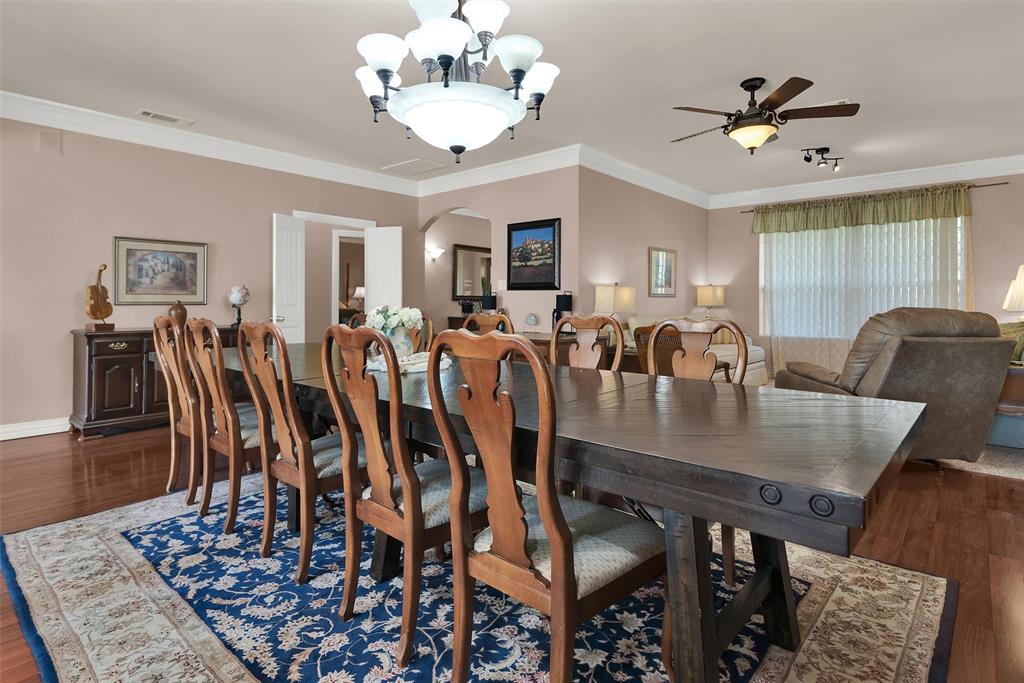 Formal dining area with wood-finish flooring, crown molding, and a chandelier Formal dining area with wood-finish flooring, crown molding, and a chandelier