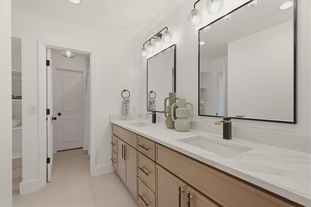 Dual vanity with wood-finish cabinetry, integrated rectangular sinks, and white countertops