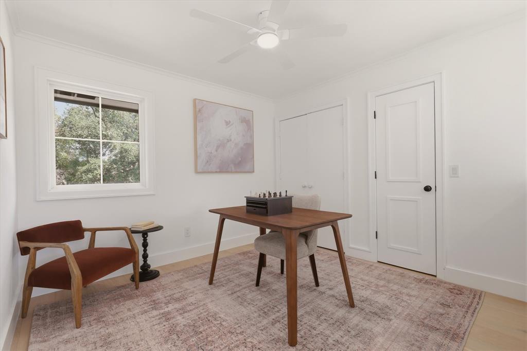 Light wood-finish flooring, white walls, and a ceiling fan with integrated lighting