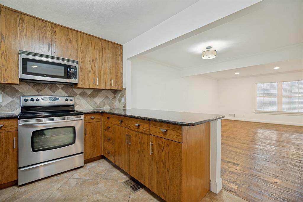 Kitchen featuring wood-finish cabinetry, stainless steel appliances, and a tiled backsplash