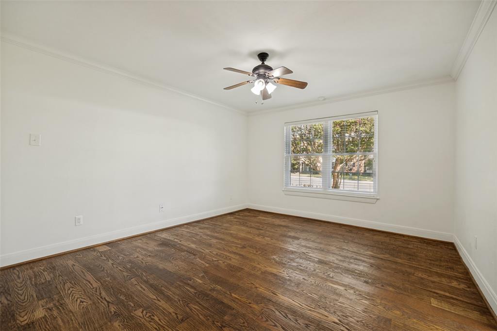 Wood-finish flooring, ceiling fan with integrated lighting, crown molding, and window with blinds