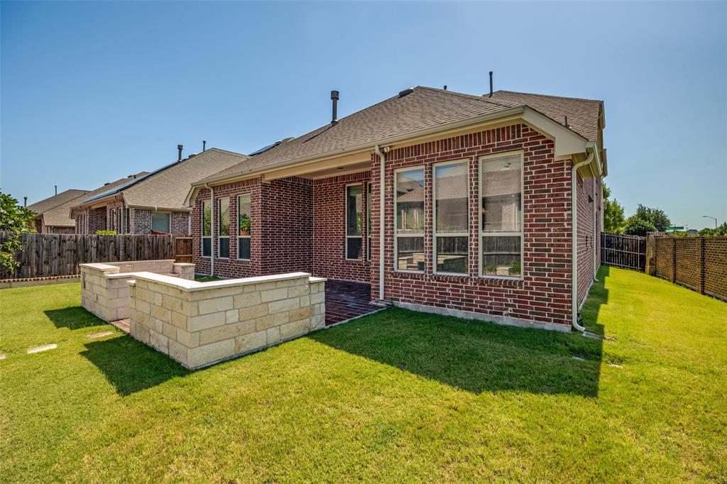 Brick exterior, large backyard, stone retaining walls, covered patio, multiple windows