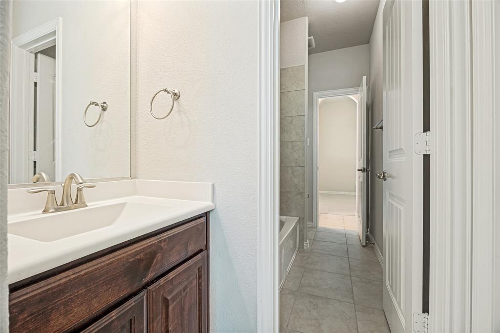 Wood-finish vanity with a white countertop and undermount sink