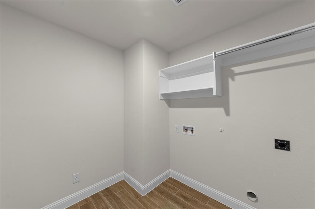 Wood-finish flooring, white built-in shelving, white trim, and light-toned walls