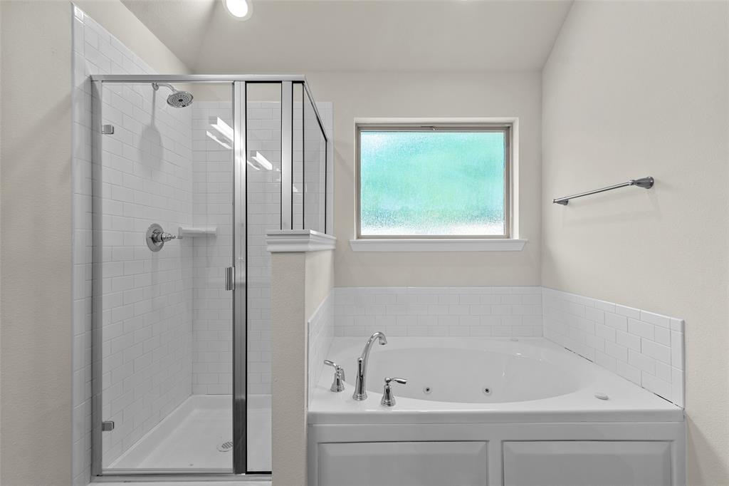 Enclosed shower with subway tile surround, clear glass door, and chrome fixtures
