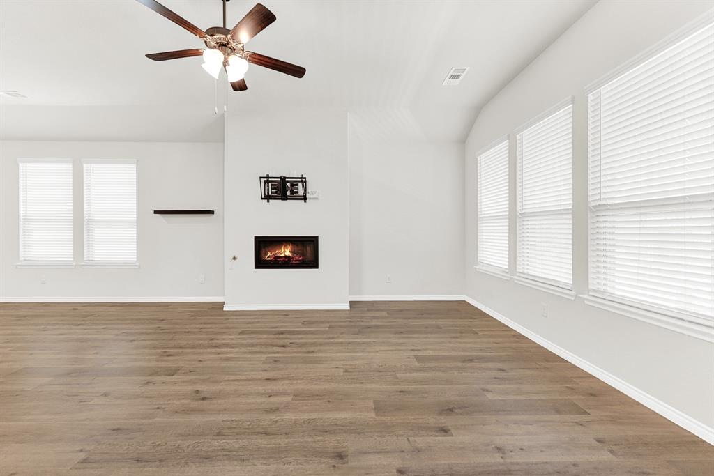 Abundant natural light streams through multiple large windows, emphasizing the stunning wood-look flooring and a modern, glowing fireplace as the room's warm focal point. This sanctuary is designed for comfort and effortless relaxation, offering a perfect, sunny spot to unwind. Abundant natural light streams through multiple large windows, emphasizing the stunning wood-look flooring and a modern, glowing fireplace as the room's warm focal point. This sanctuary is designed for comfort and effortless relaxation, offering a perfect, sunny spot to unwind.