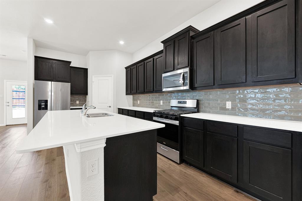 This close-up shot focuses on the main cooking wall, showing the full appliance package with gas range and the contrast between the cabinetry and backsplash. Meal preparation is a joy with modern tools in such a well-appointed, attractive space. This close-up shot focuses on the main cooking wall, showing the full appliance package with gas range and the contrast between the cabinetry and backsplash. Meal preparation is a joy with modern tools in such a well-appointed, attractive space.