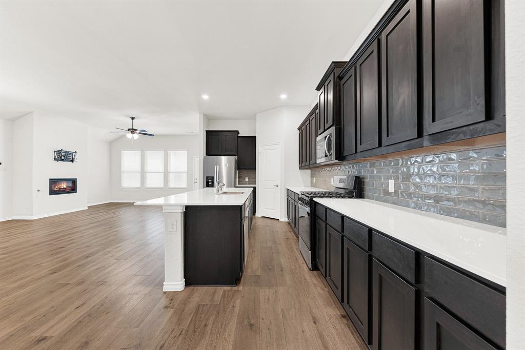 This wide perspective highlights the rich espresso cabinetry and the unique gray subway tile backsplash that runs the length of the kitchen counter. Preparing dinner feels efficient and organized when you have this much counter space and such sleek surfaces. This wide perspective highlights the rich espresso cabinetry and the unique gray subway tile backsplash that runs the length of the kitchen counter. Preparing dinner feels efficient and organized when you have this much counter space and such sleek surfaces.