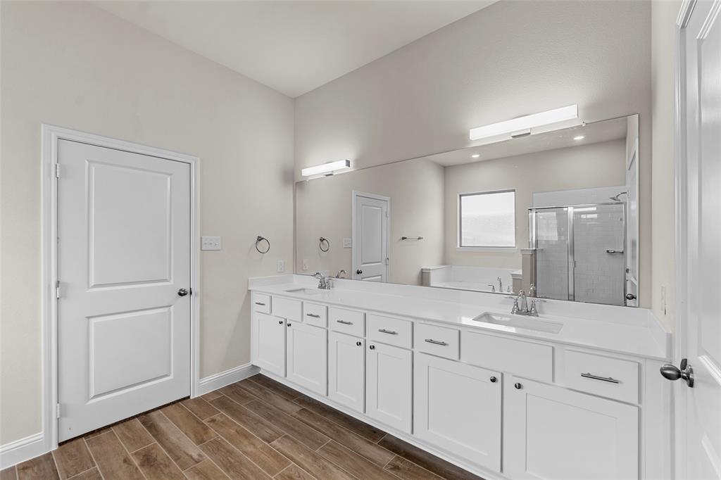 Dual vanity with white cabinetry, integrated sinks, and polished chrome fixtures