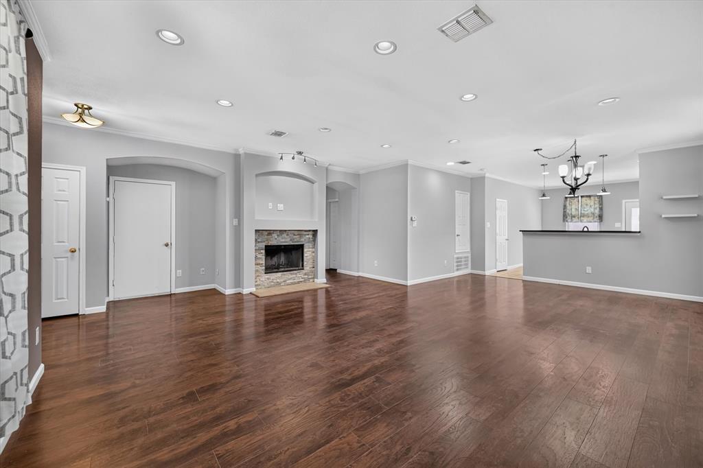 Wood-finish flooring throughout, recessed lighting, and a stone-faced fireplace