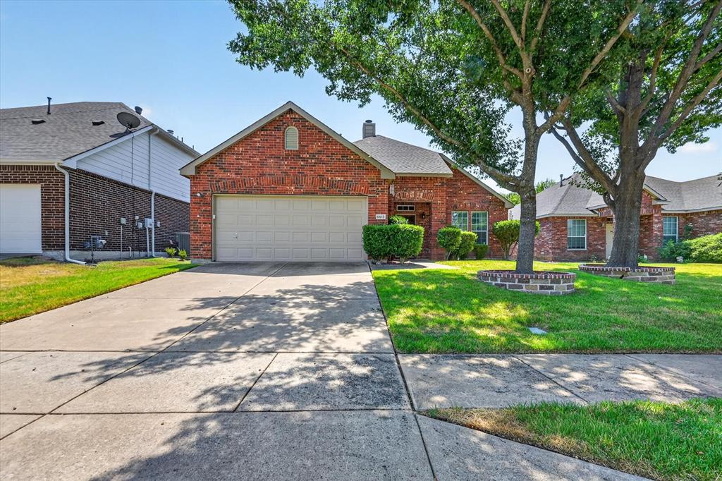Brick exterior, attached garage, concrete driveway, mature trees, landscaped front yard