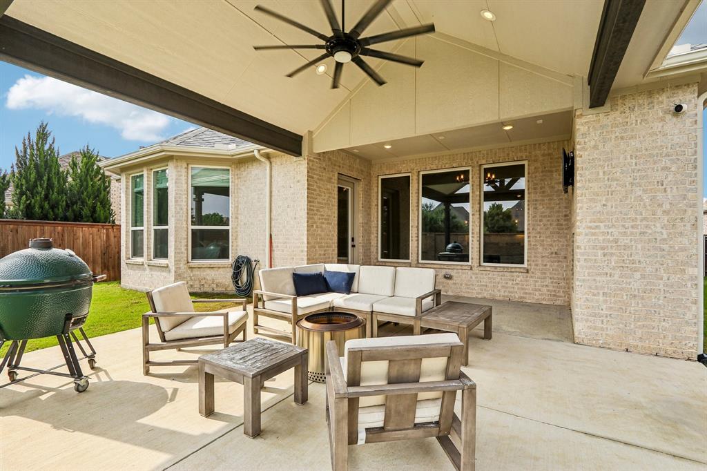 Covered outdoor patio with a ceiling fan, recessed lighting, and a brick exterior