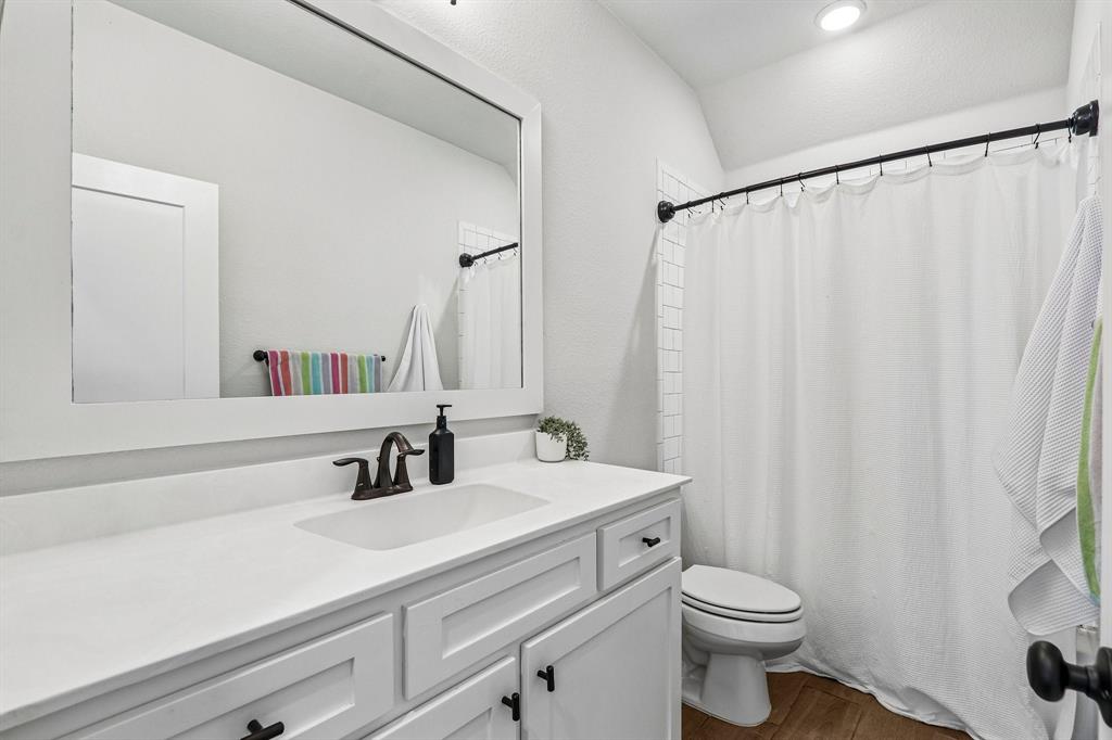 Single vanity with white countertop, integrated sink, and bronze-finish faucet
