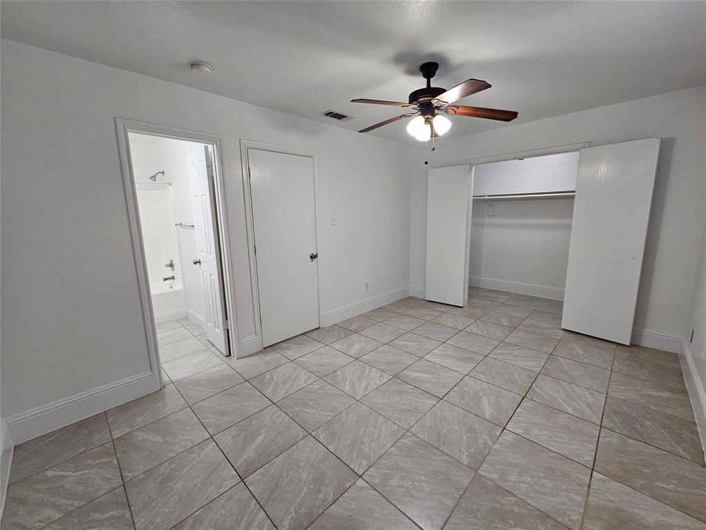 Tiled flooring throughout, ceiling fan with integrated lighting, and a closet with bi-fold doors