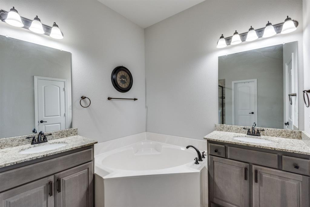 Dual vanities with granite countertops, undermount sinks, and bronze-finish fixtures
