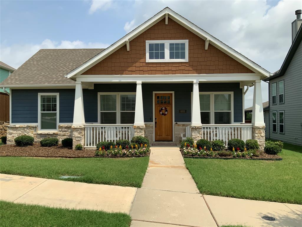 Craftsman-style facade with a prominent front porch, stone accents, and varied siding materials