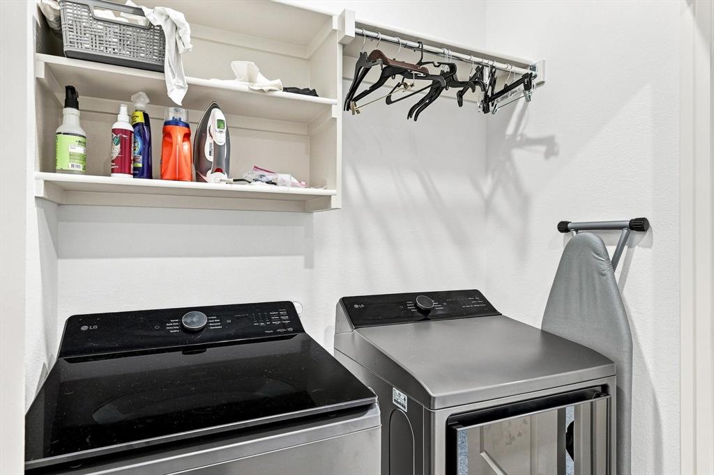 Smart storage makes this laundry area exceptionally functional, with shelving, hanging space, and room to keep everything neatly organized.