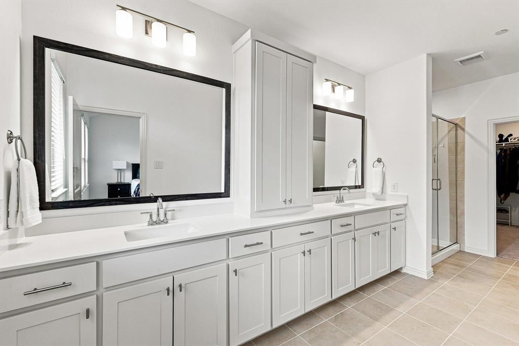 Space to spread out and start the day right. An expansive dual-sink vanity, abundant cabinetry, and oversized mirrors bring both style and function to the primary bath.