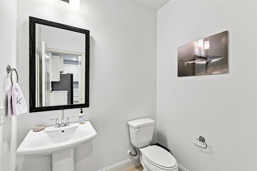 A conveniently located main-level powder bath adds everyday function while maintaining the home’s clean, contemporary aesthetic.