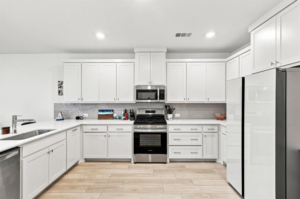 Storage meets style. An impressive wall of cabinetry, abundant counter space, and sleek stainless appliances give this kitchen the clean, elevated look buyers love.