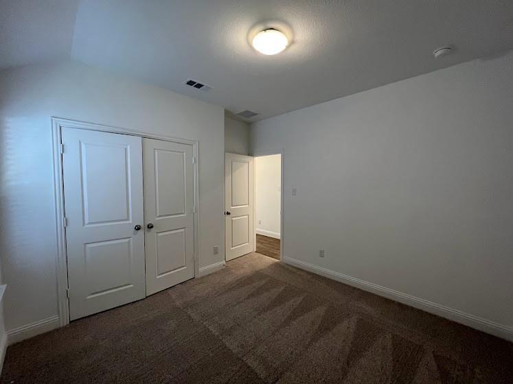 Neutral-toned carpeting, white walls, and white trim
