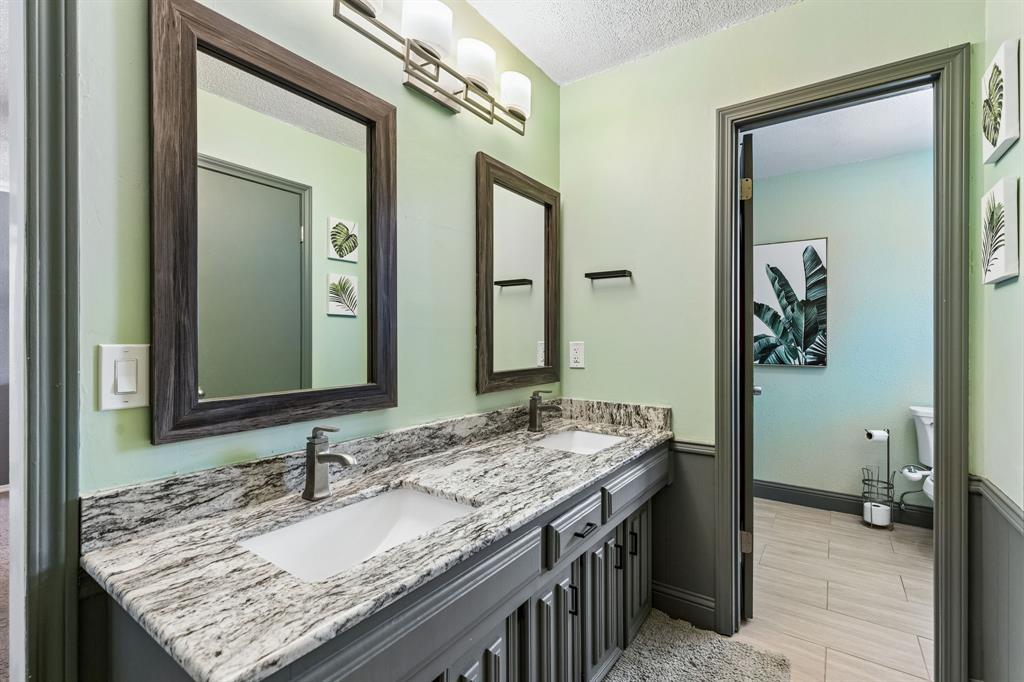 Double vanity with undermount sinks, stone countertop, and two framed mirrors