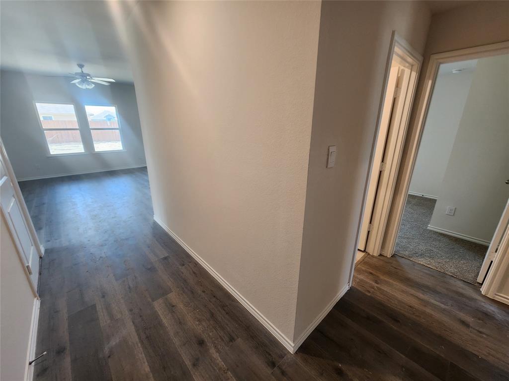 Wood-finish flooring throughout the main areas, with light gray carpeting in additional rooms