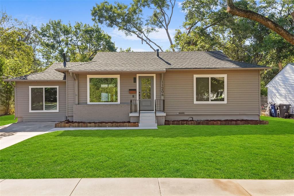 Single-story residence featuring light-colored siding, a dark shingle roof, and a neatly manicured lawn