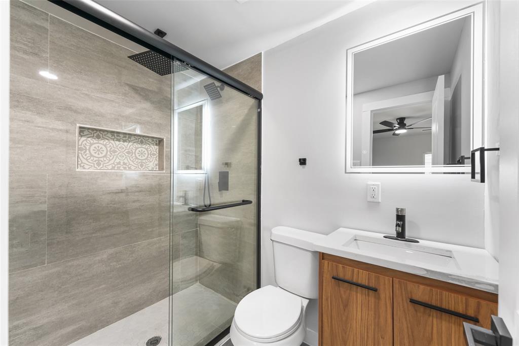 Glass-enclosed shower with a rainfall showerhead and tiled niche Glass-enclosed shower with a rainfall showerhead and tiled niche