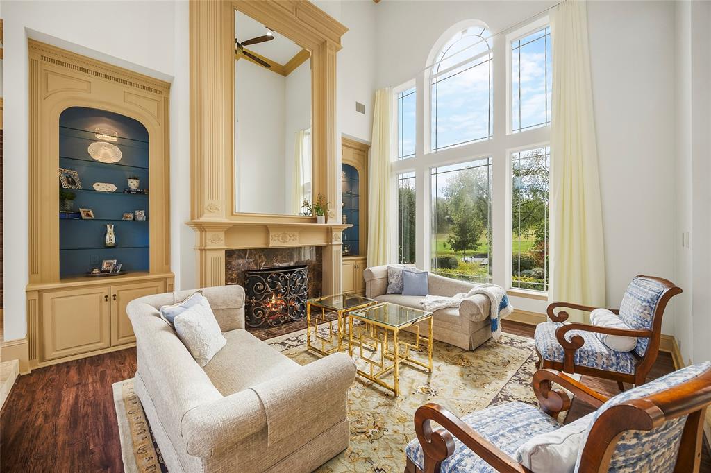 Elegant formal living room with floor-to-ceiling windows and a beautiful fireplace. Elegant formal living room with floor-to-ceiling windows and a beautiful fireplace.
