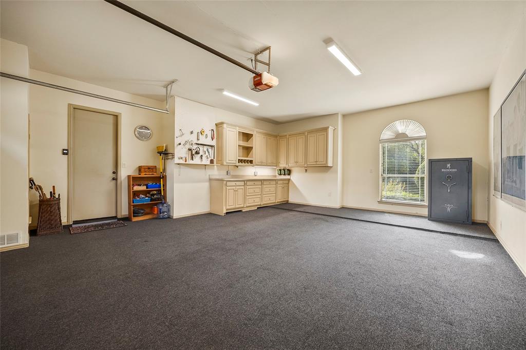Spacious garage with custom built-in storage and room for a workshop.