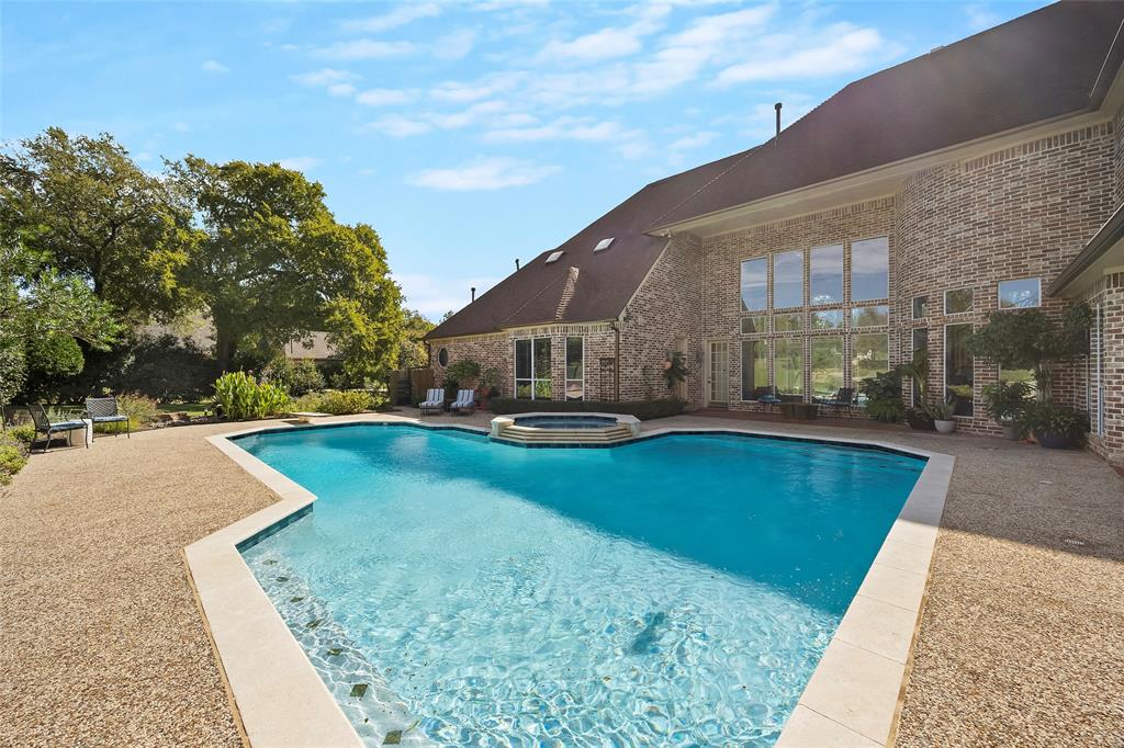 Sparkling pool and spa surrounded by expansive patio space for entertaining.
