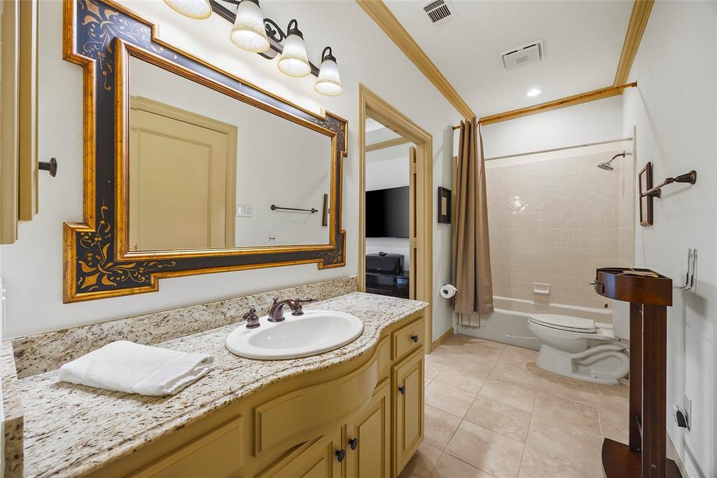 Well-appointed bathroom with stone countertops and custom cabinetry.