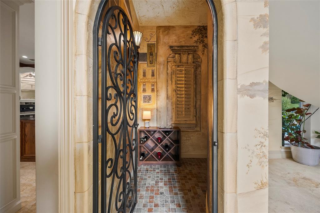 Walk-in wine closet with custom storage and decorative iron door. Walk-in wine closet with custom storage and decorative iron door.