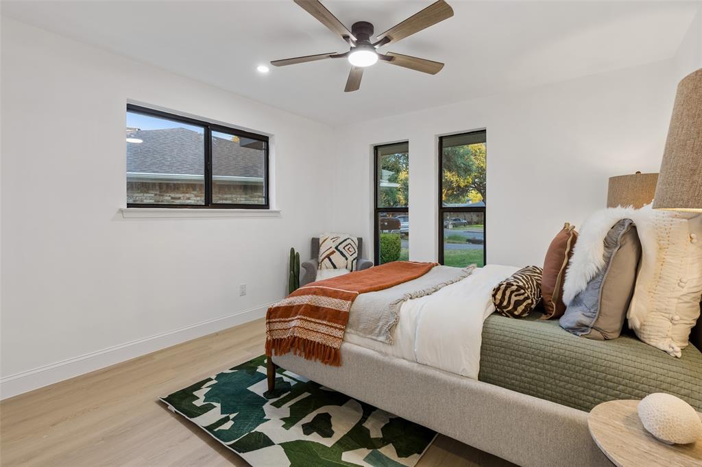 Wood-finish flooring, white walls, and a ceiling fan with integrated lighting