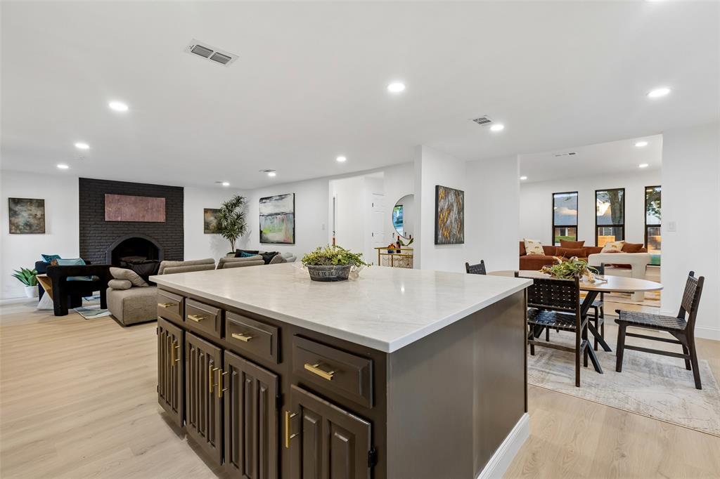 Central kitchen island with a stone countertop and dark wood cabinetry