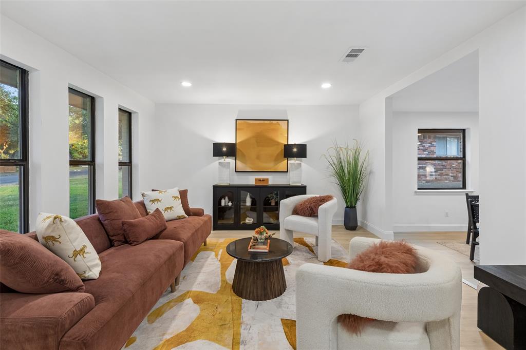 Spacious living area featuring multiple large windows, recessed lighting, and light wood-finish flooring